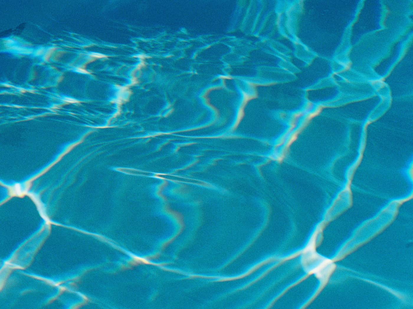 Sunlit ripples across blue pool water