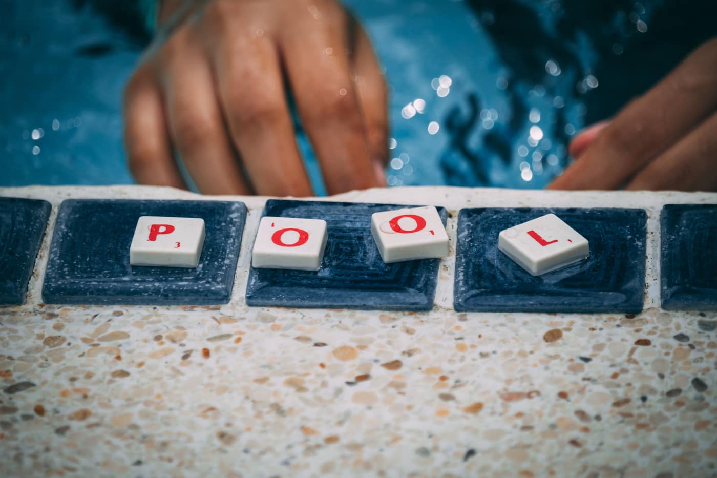 A pool water test vial and reagent bottle at the poolside