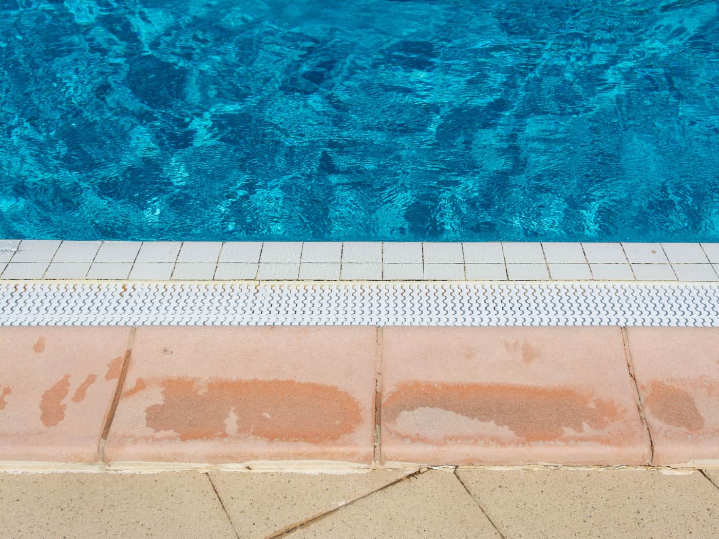 The tiled edge of a swimming pool in summer sun