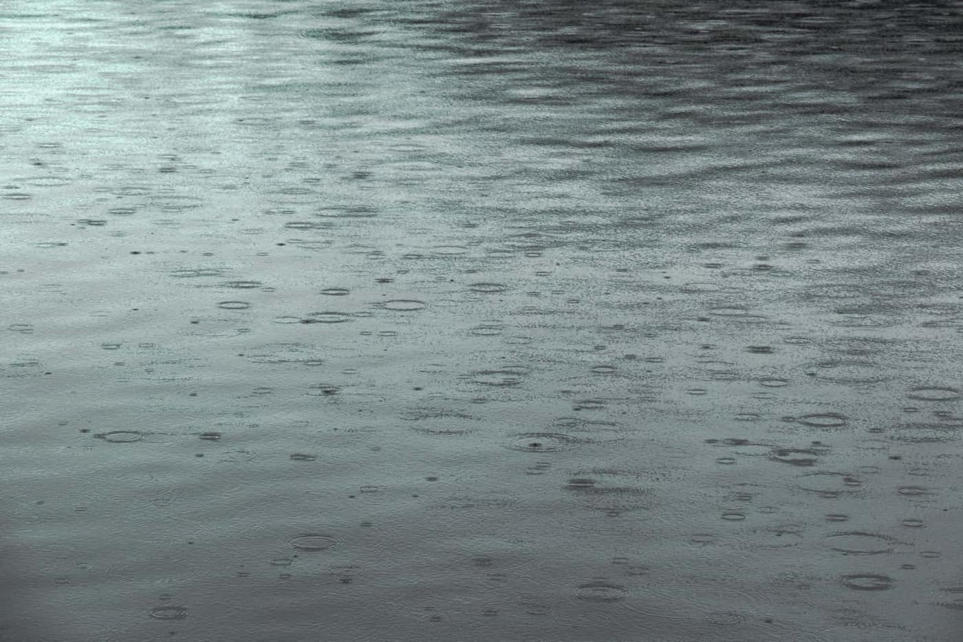 Rain falling onto the surface of a swimming pool during a storm
