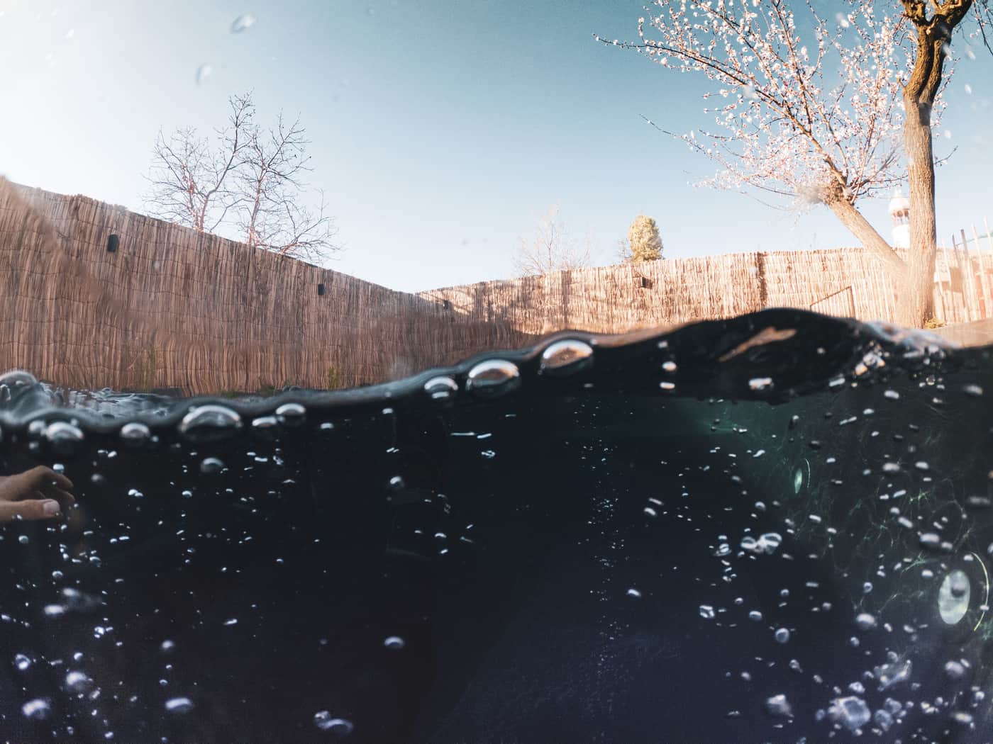 A half-submerged view of pool water and bubbles
